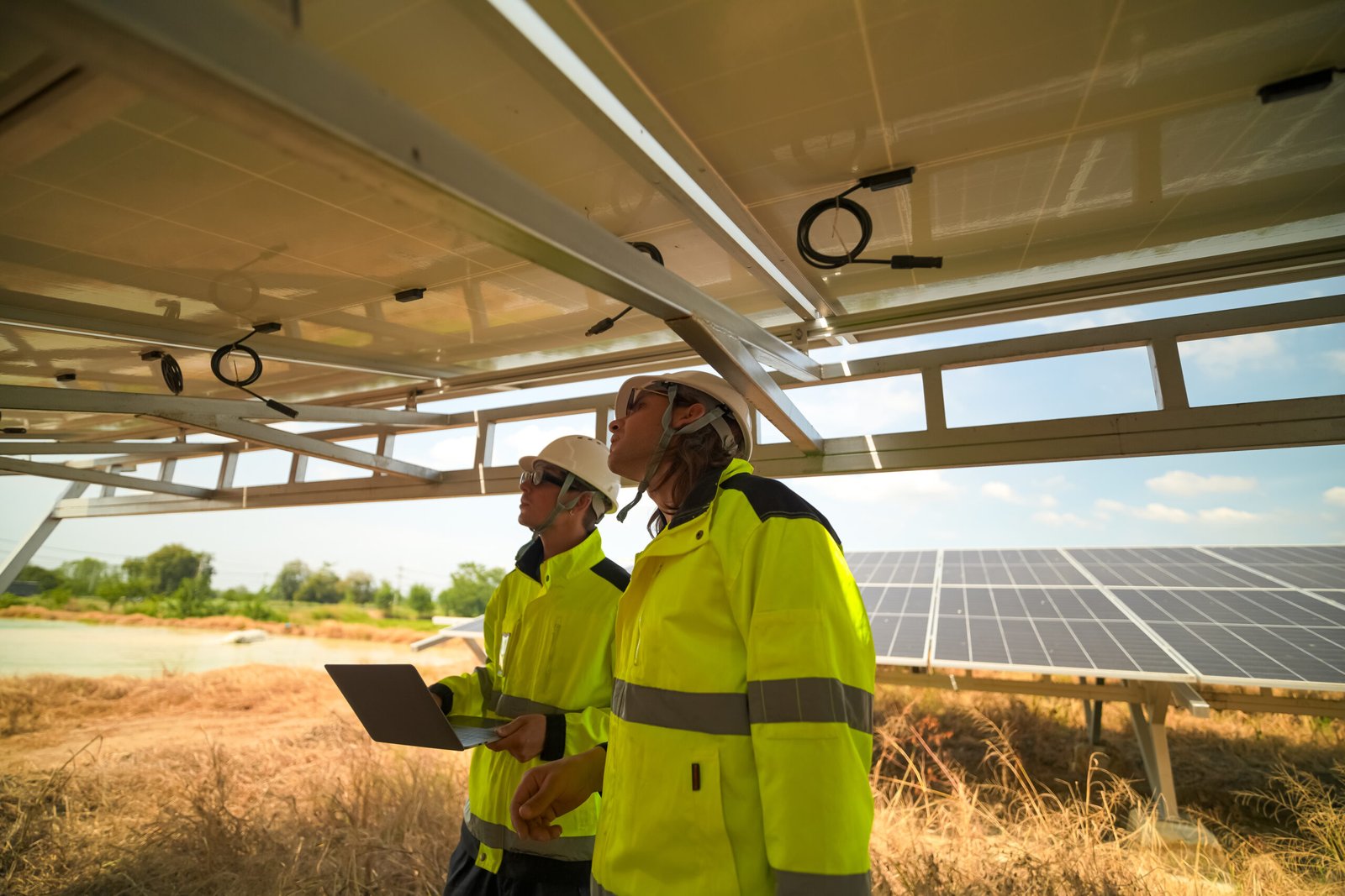 Ingenieros revisando soportes y anclajes de una instalación fotovoltaica en campo.