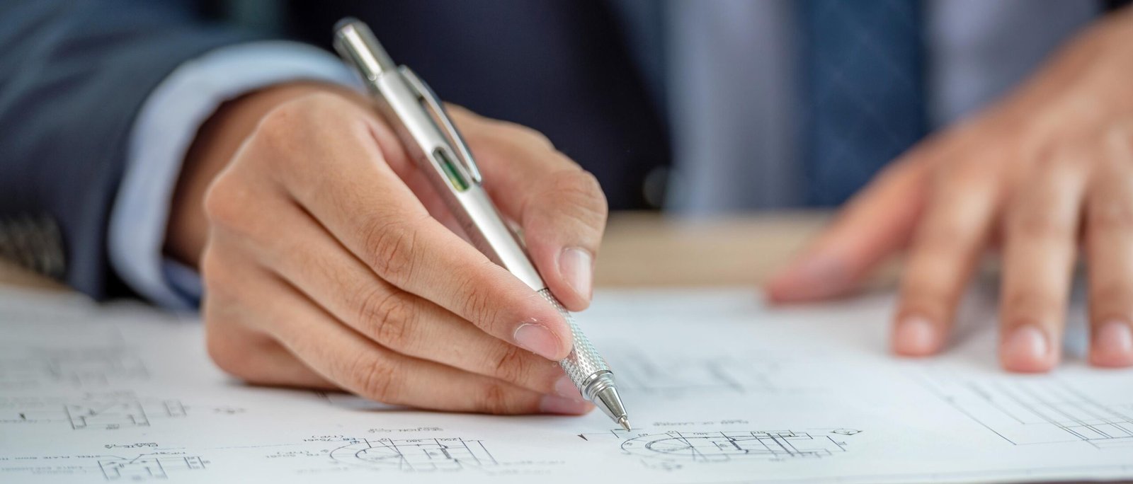 Firma de ingeniero sobre plano técnico para emitir certificado estructural.